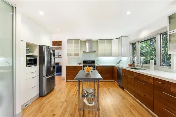 a kitchen with stainless steel appliances granite countertop a refrigerator a stove and a wooden floors