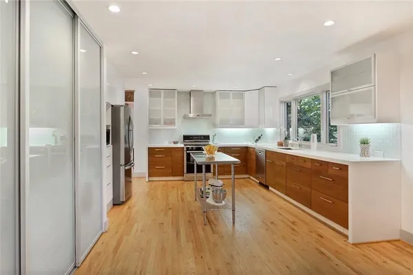 a living room with stainless steel appliances granite countertop furniture wooden floor and a view of kitchen