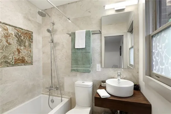 a bathroom with a tub sink and mirror