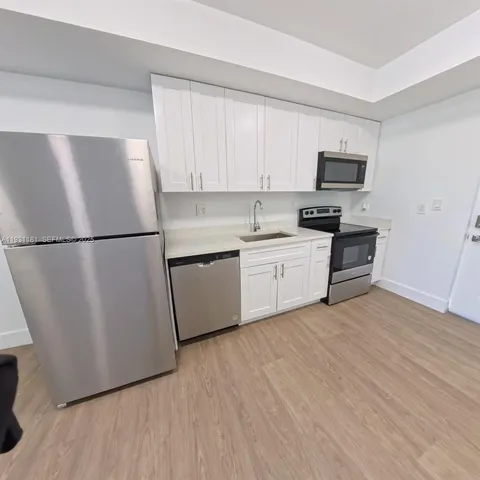 a kitchen with stainless steel appliances a refrigerator sink and cabinets