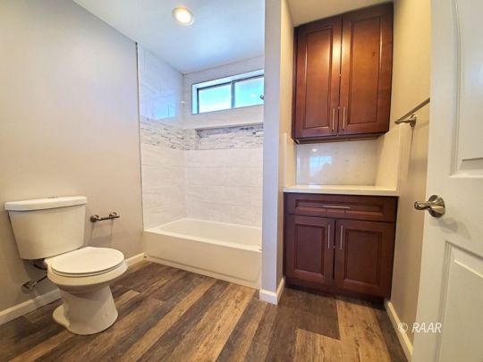 128 South Lilac Street Ridgecrest, CA 93555 - Photo 8 of 24 a bathroom with a toilet and a bathtub