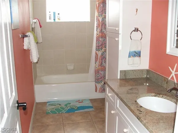 a bathroom with a granite countertop sink a toilet and shower