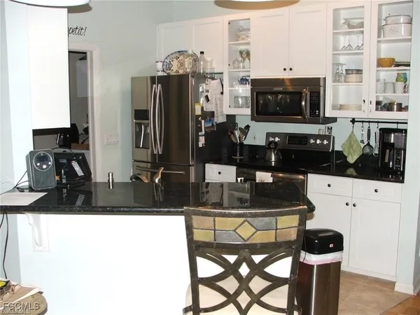 a kitchen with refrigerator and cabinets