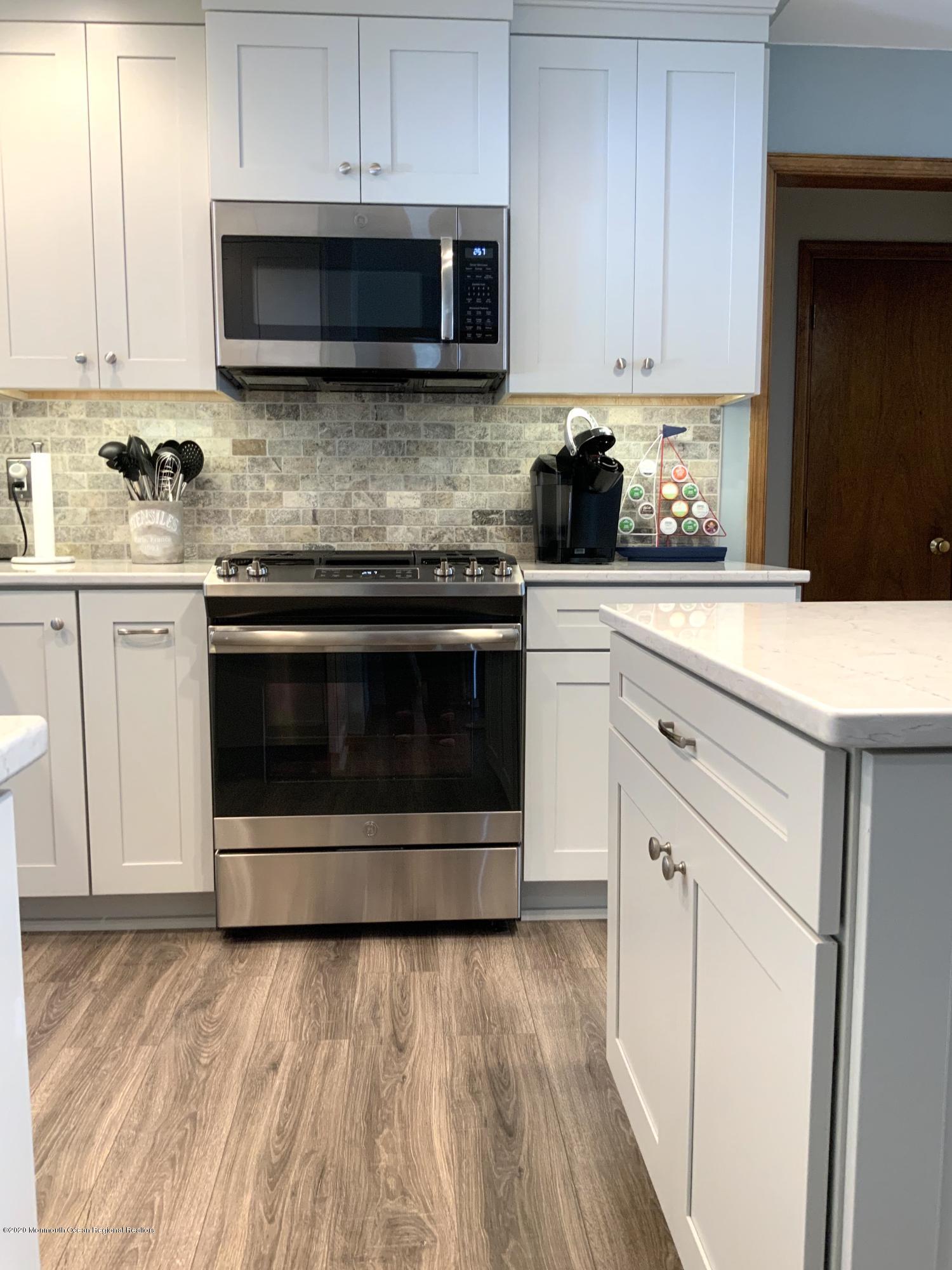 202 Pleasant Drive Brick, NJ 08723 - Photo 6 of 46 a kitchen with stainless steel appliances granite countertop a stove a sink and a microwave