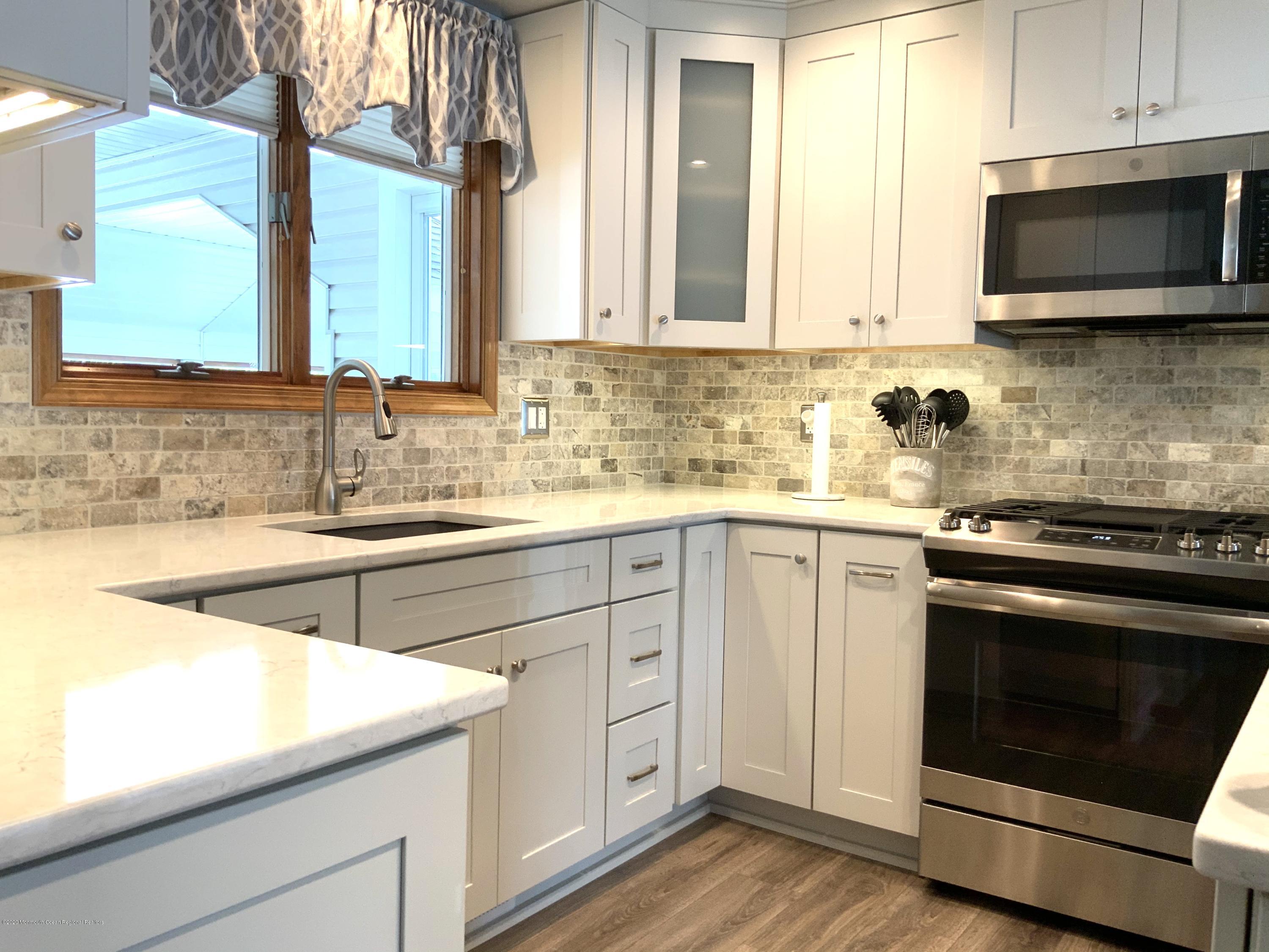 202 Pleasant Drive Brick, NJ 08723 - Photo 7 of 46 a kitchen with stainless steel appliances granite countertop a sink and a stove