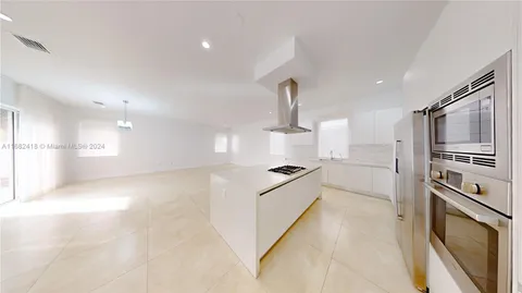 a view of empty room with window and wooden floor