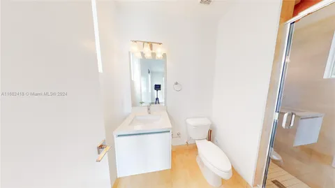 a bathroom with a sink and mirror with toilet