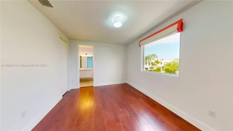 a view of a kitchen with kitchen island a sink wooden floor and a large window