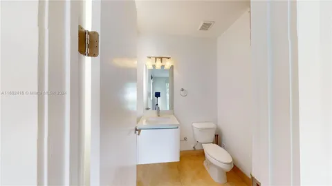 a bathroom with a granite countertop sink toilet a mirror and shower