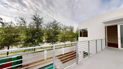 a view of a hallway with wooden floor and a potted plant