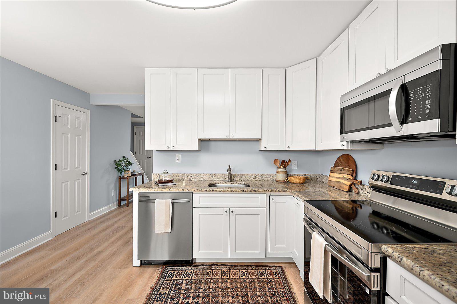 135 Jamestown Road, Unit 18A Ocean City, MD 21842 - Photo 18 of 63 a kitchen with stainless steel appliances granite countertop a stove a sink and a microwave
