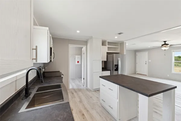 a spacious bathroom with a granite countertop sink and a bathtub