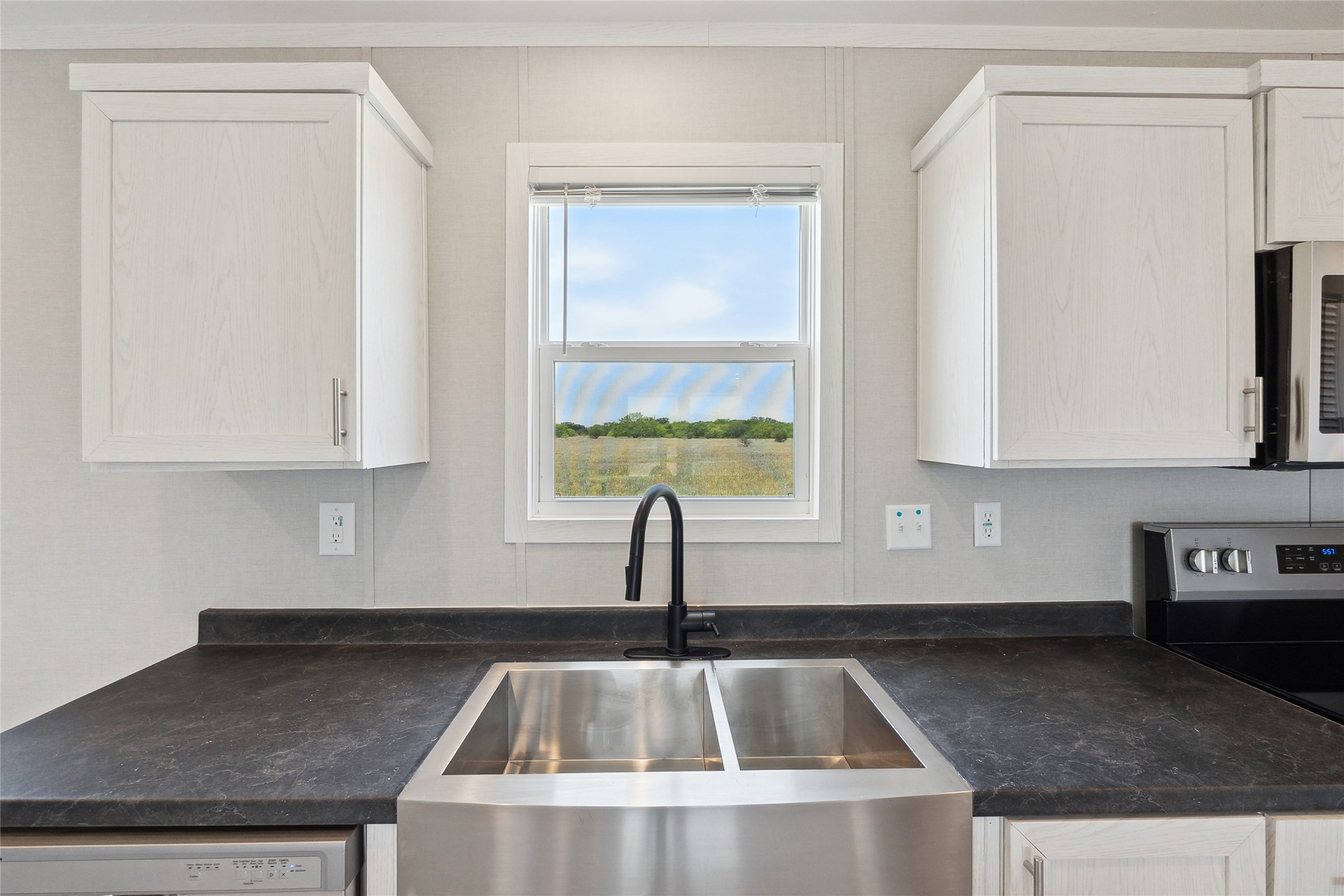 1287 Cr 402 Roads, Unit LOT 17 Flatonia, TX 78941 - Photo 19 of 37 Kitchen featuring a sink, stainless steel appliances, dark countertops, and white cabinetry