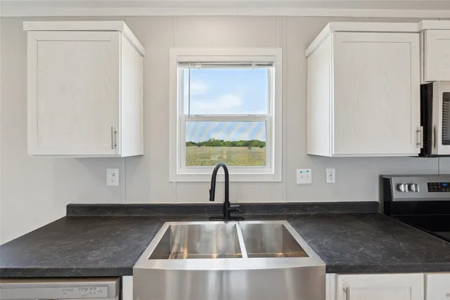 a kitchen with granite countertop a sink and a window