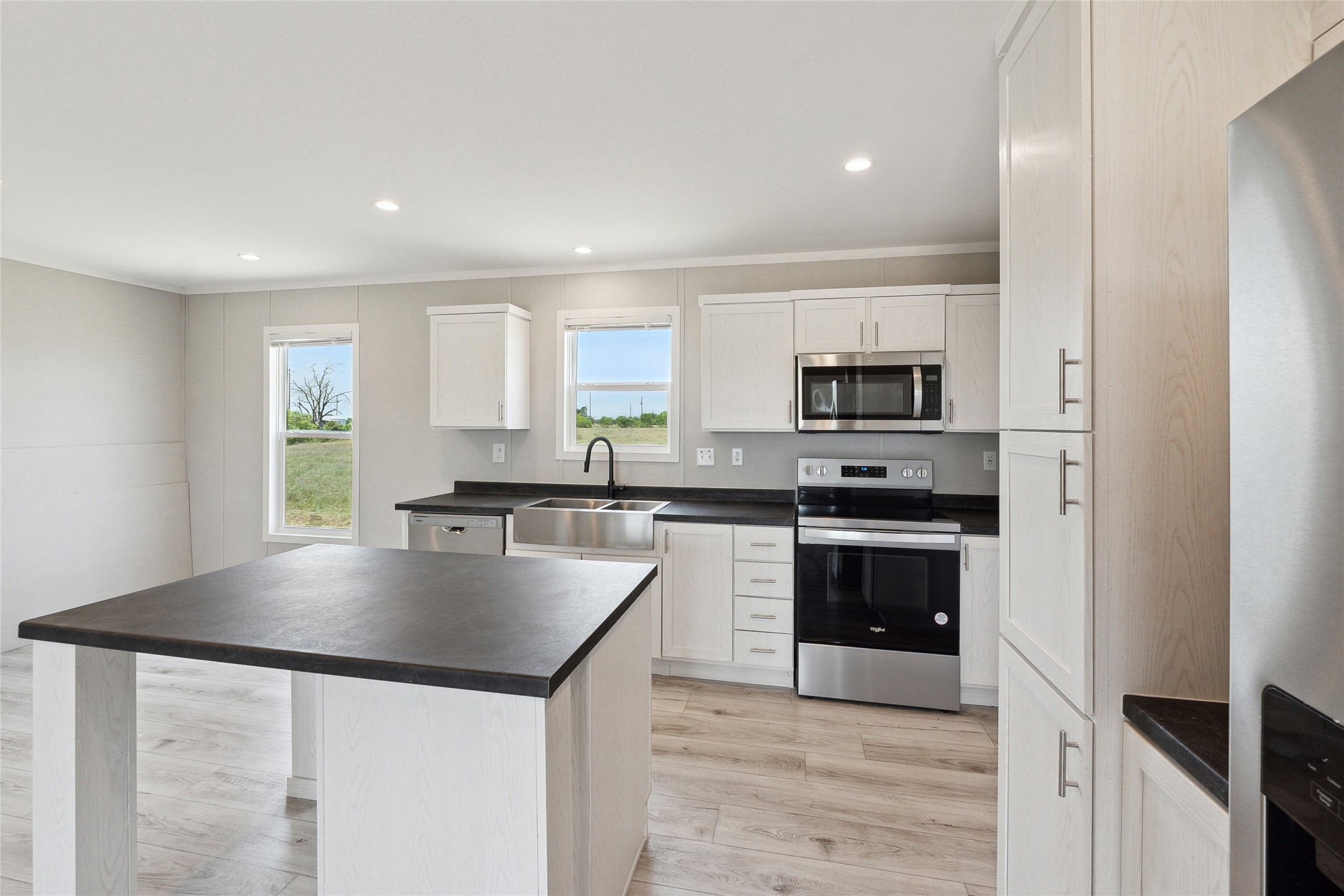 1287 Cr 402 Roads, Unit LOT 17 Flatonia, TX 78941 - Photo 21 of 37 Kitchen with stainless steel appliances, a sink, dark countertops, ornamental molding, and light wood-style flooring