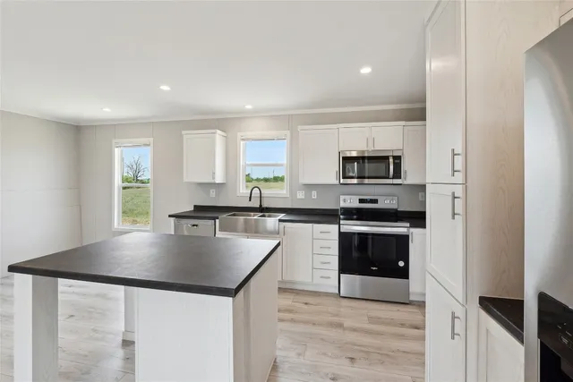 a kitchen with granite countertop a stove a sink and a refrigerator