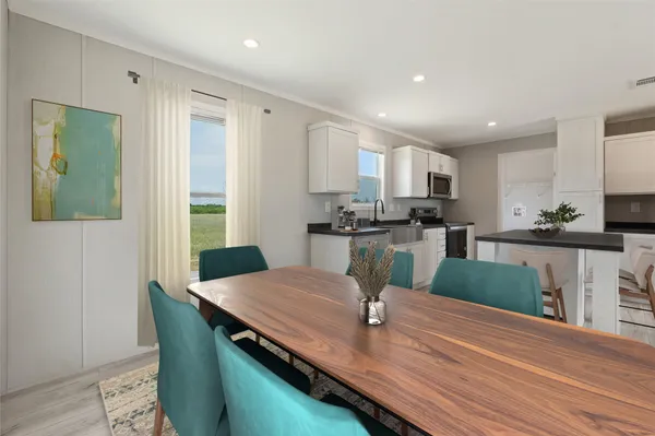 a kitchen with granite countertop kitchen island stainless steel appliances a sink and a refrigerator