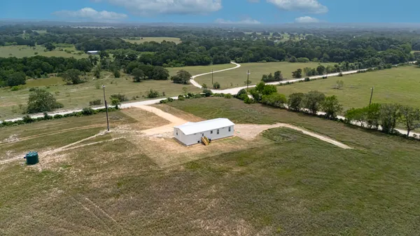 an aerial view of a house with a yard and lake view