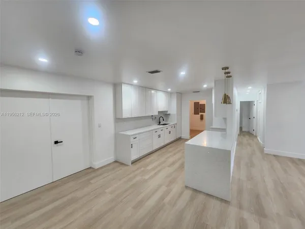 a view of an empty room with a kitchen