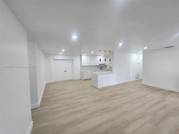 a big room with wooden floor and windows