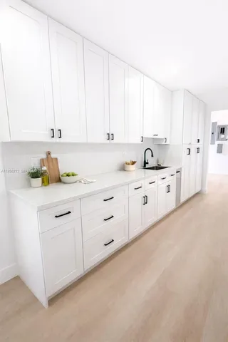 a kitchen with granite countertop white cabinets and white appliances
