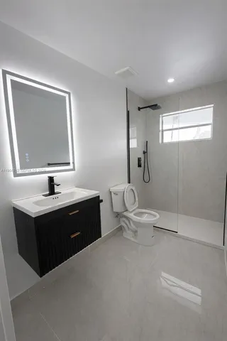 a spacious bathroom with a bathtub sink mirror and toilet