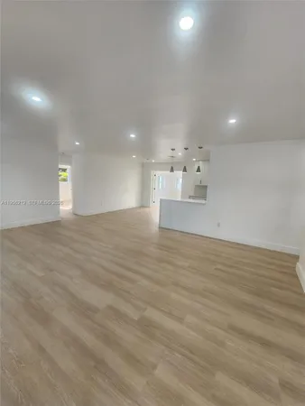 a large kitchen with stainless steel appliances granite countertop a stove a sink a refrigerator and white cabinets