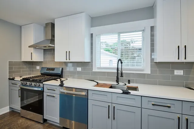 a kitchen with stainless steel appliances a sink a stove and cabinets