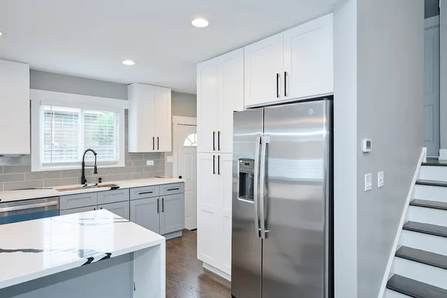 a kitchen with stainless steel appliances granite countertop a refrigerator and a sink