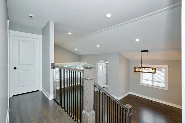 a view of a hallway with wooden floor and windows