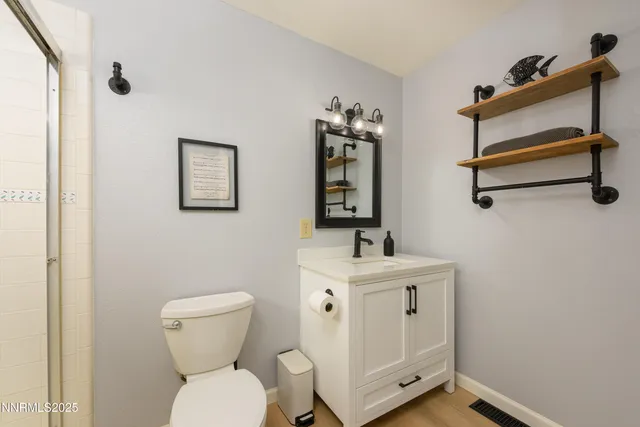 a bathroom with a toilet a sink and mirror