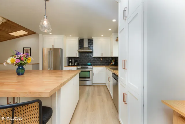 a kitchen with kitchen island wooden cabinets and refrigerator