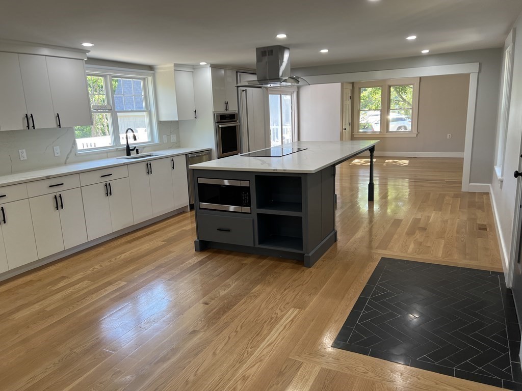 138 High Street Hingham, MA 02043 - Photo 2 of 23 a large kitchen with stainless steel appliances a large counter top a stove and a wooden floors