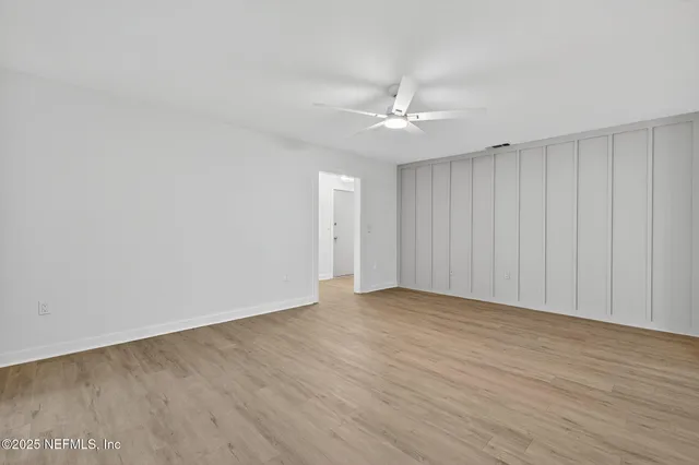 a view of an empty room with wooden floor