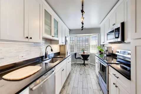 a kitchen with stainless steel appliances granite countertop a sink stove and cabinets