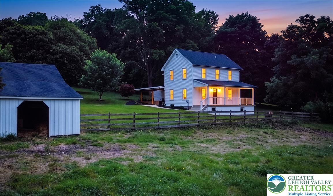 72 Allegheny Road Mount Bethel, PA 18343 - Photo 72 of 72 A classic farmhouse stands gracefully on a verdant lot, illuminated by the twilight glow.