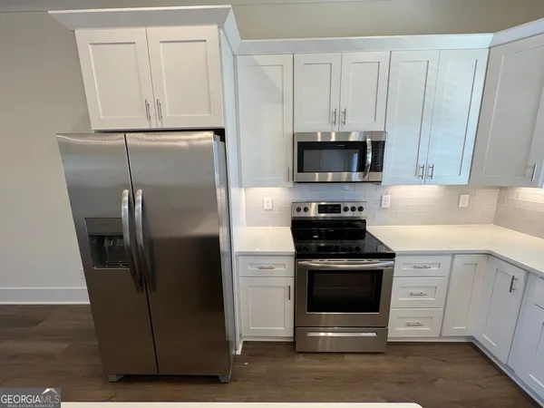 a kitchen with white cabinets and stainless steel appliances