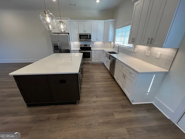 a large kitchen with kitchen island stainless steel appliances a sink window and a counter top space