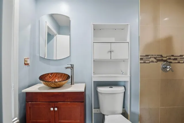 a bathroom with a toilet a sink and mirror
