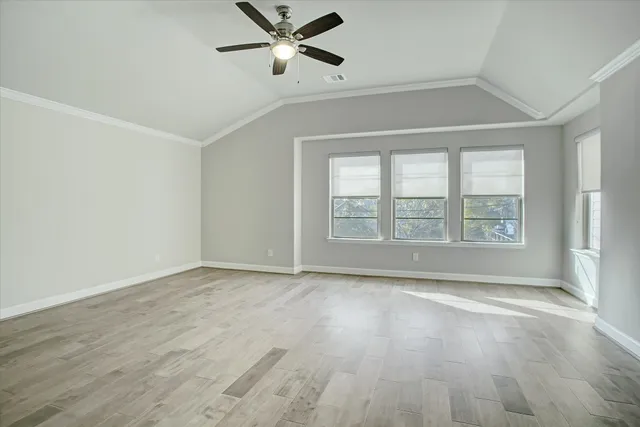 a view of an empty room with a window and wooden floor