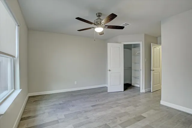 a view of a livingroom with a ceiling fan & hardwood floor