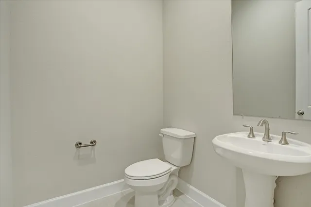a bathroom with a sink toilet and a mirror
