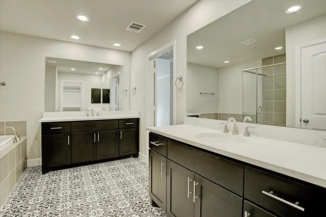 a bathroom with a sink vanity granite tub shower and a mirror