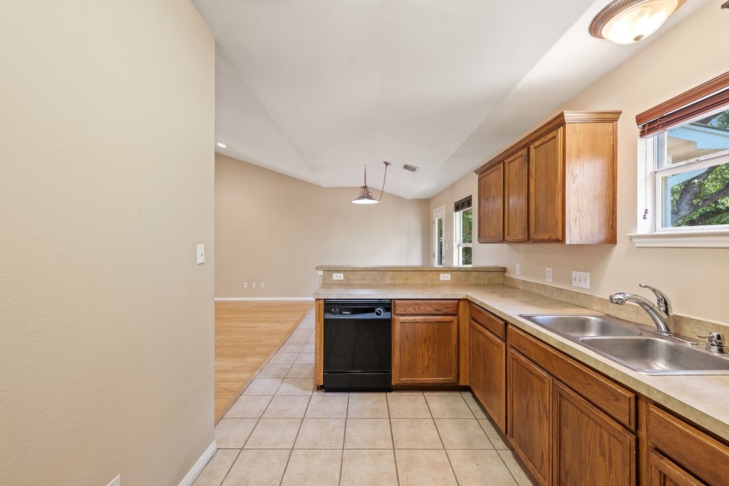 5208 Sioux Lane Austin, TX 78734 - Photo 5 of 35 Warm wood cabinetry pairs with neutral countertops, offering a welcoming space for culinary creations.
