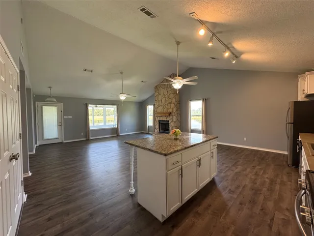 a kitchen with a stove and a wooden floor