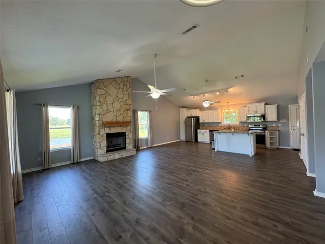 a view of a kitchen and a livingroom with furniture wooden floor kitchen