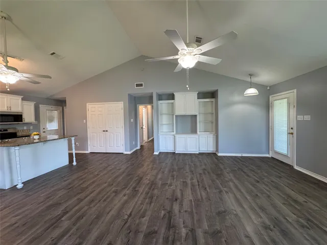 a view of an empty room with window closet area and a ceiling fan