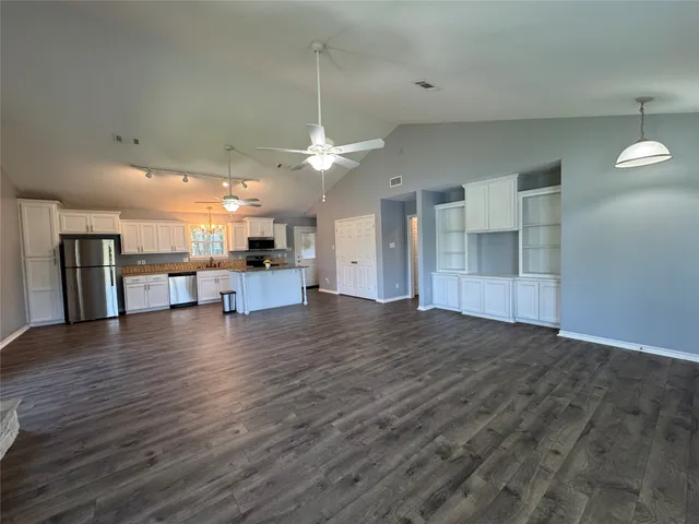 a view of a kitchen with a refrigerator and a stove top oven