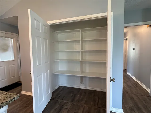 a view of walk in closet with empty racks