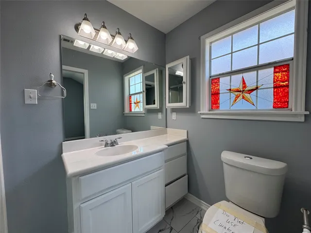 a bathroom with a sink a toilet and a mirror